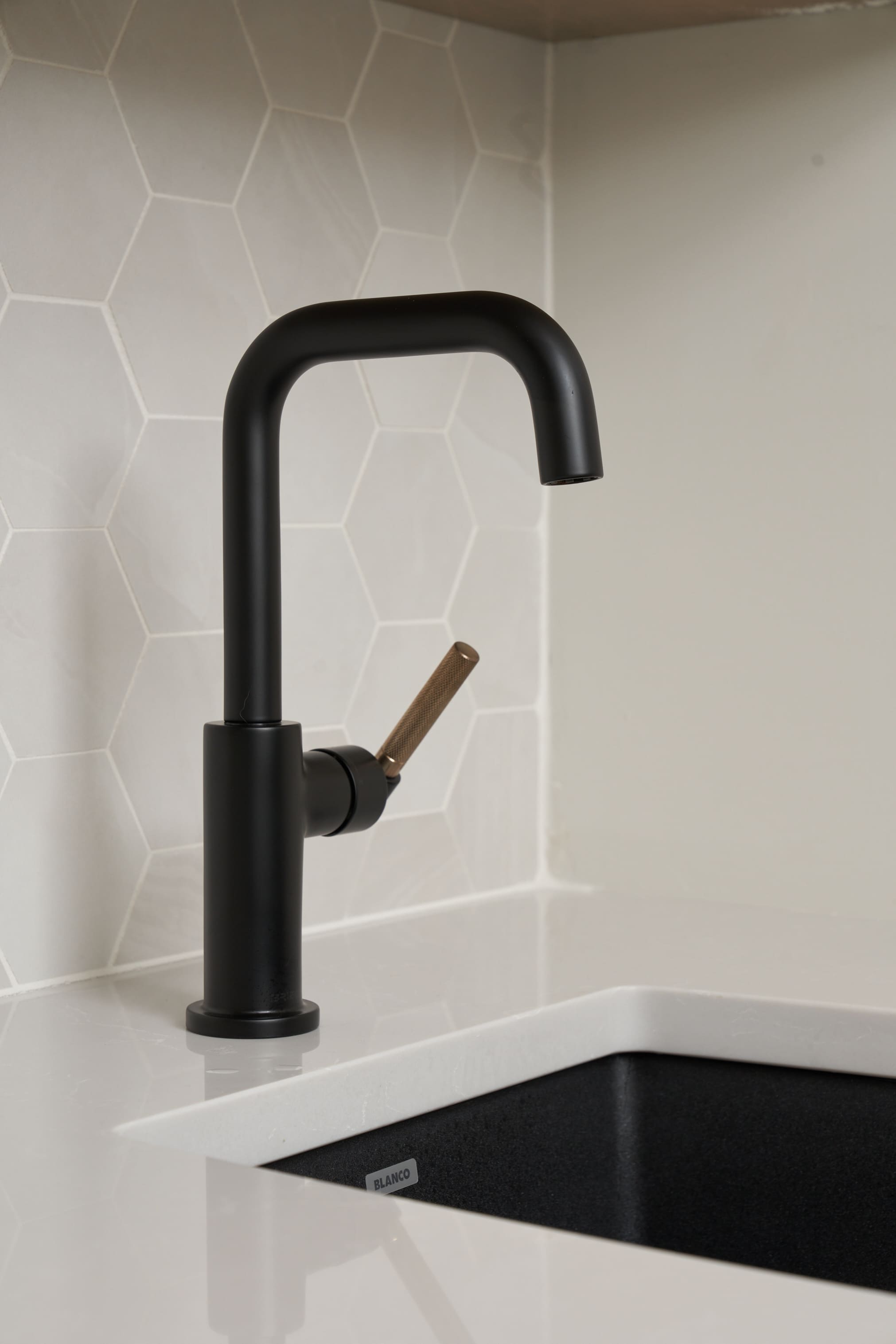 black faucet wet bar with hexagon backsplash