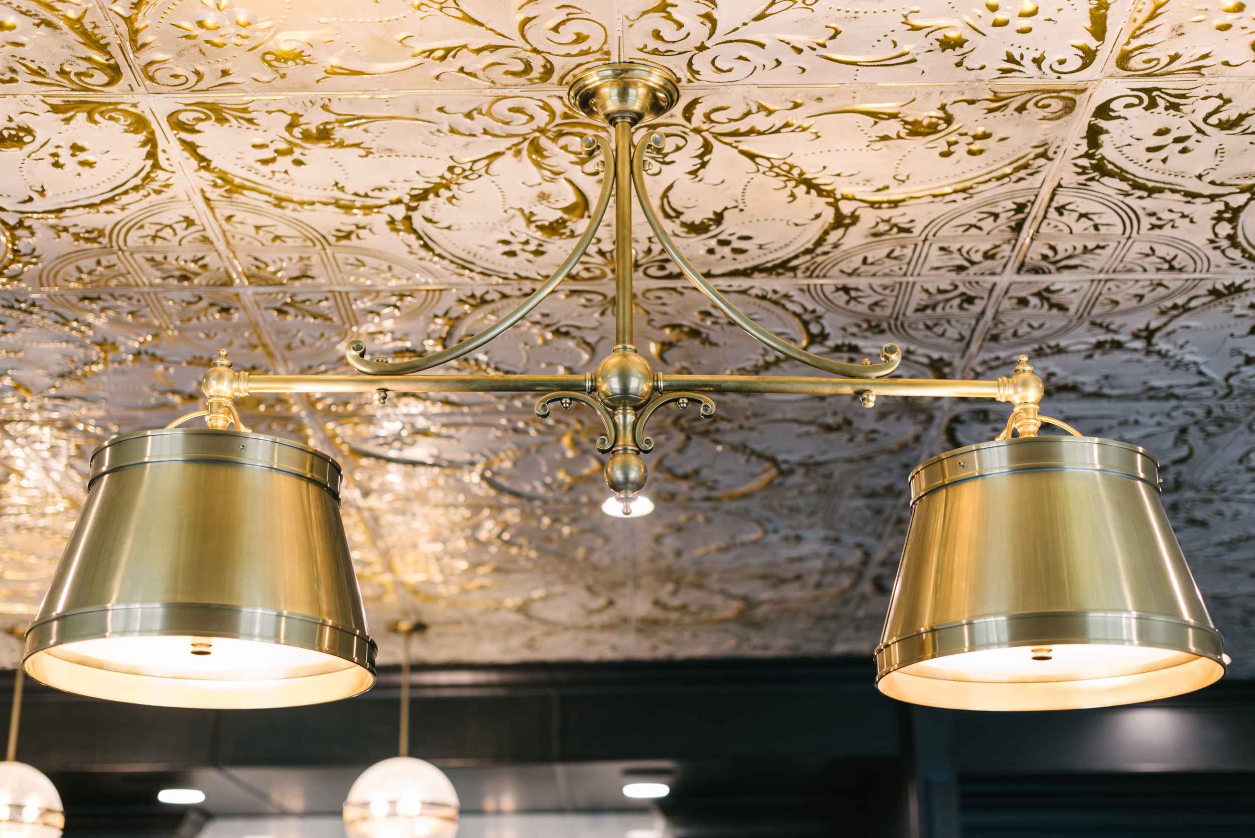 golden light fixture with pattern ceiling 