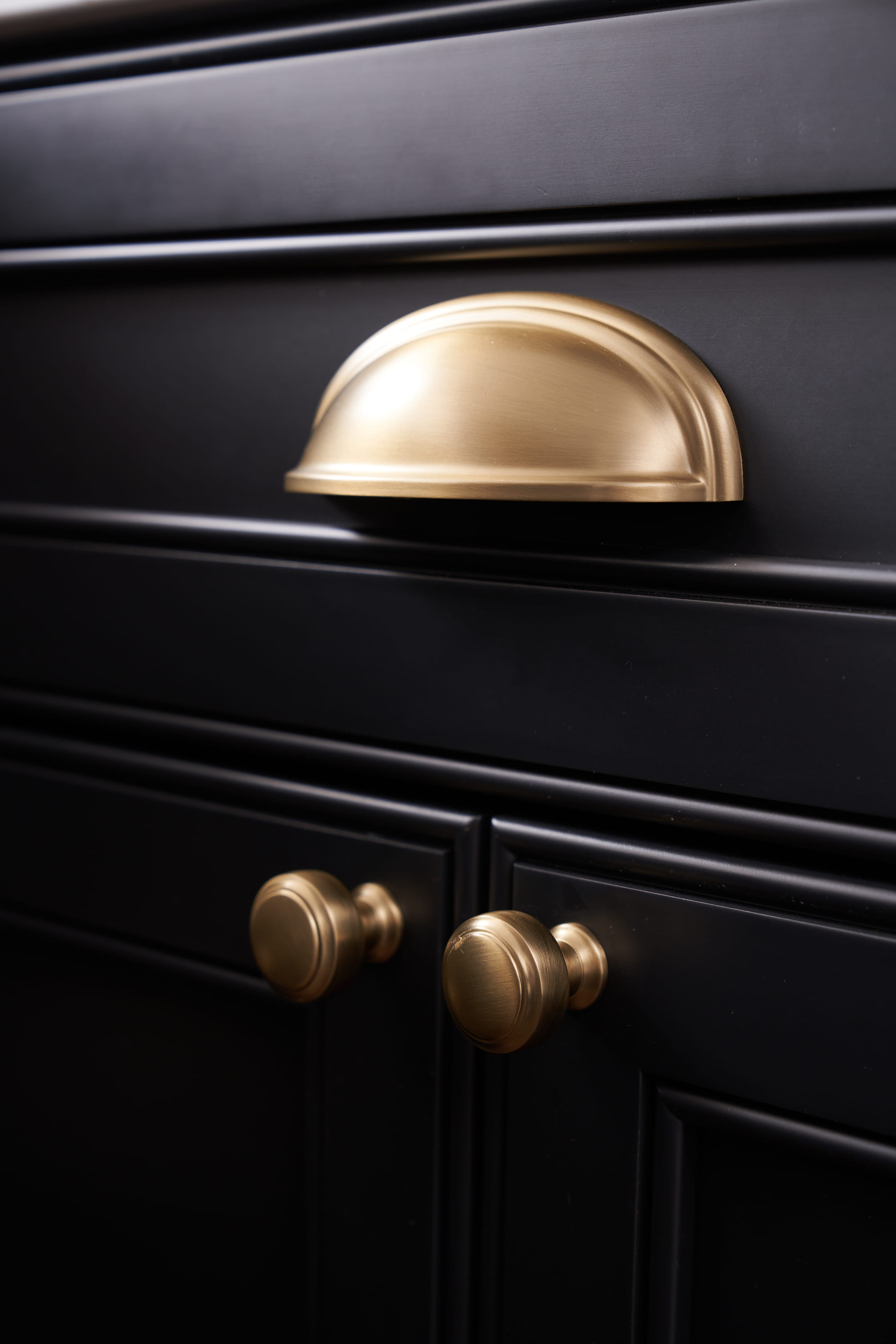 gold hardware on black cabinet 