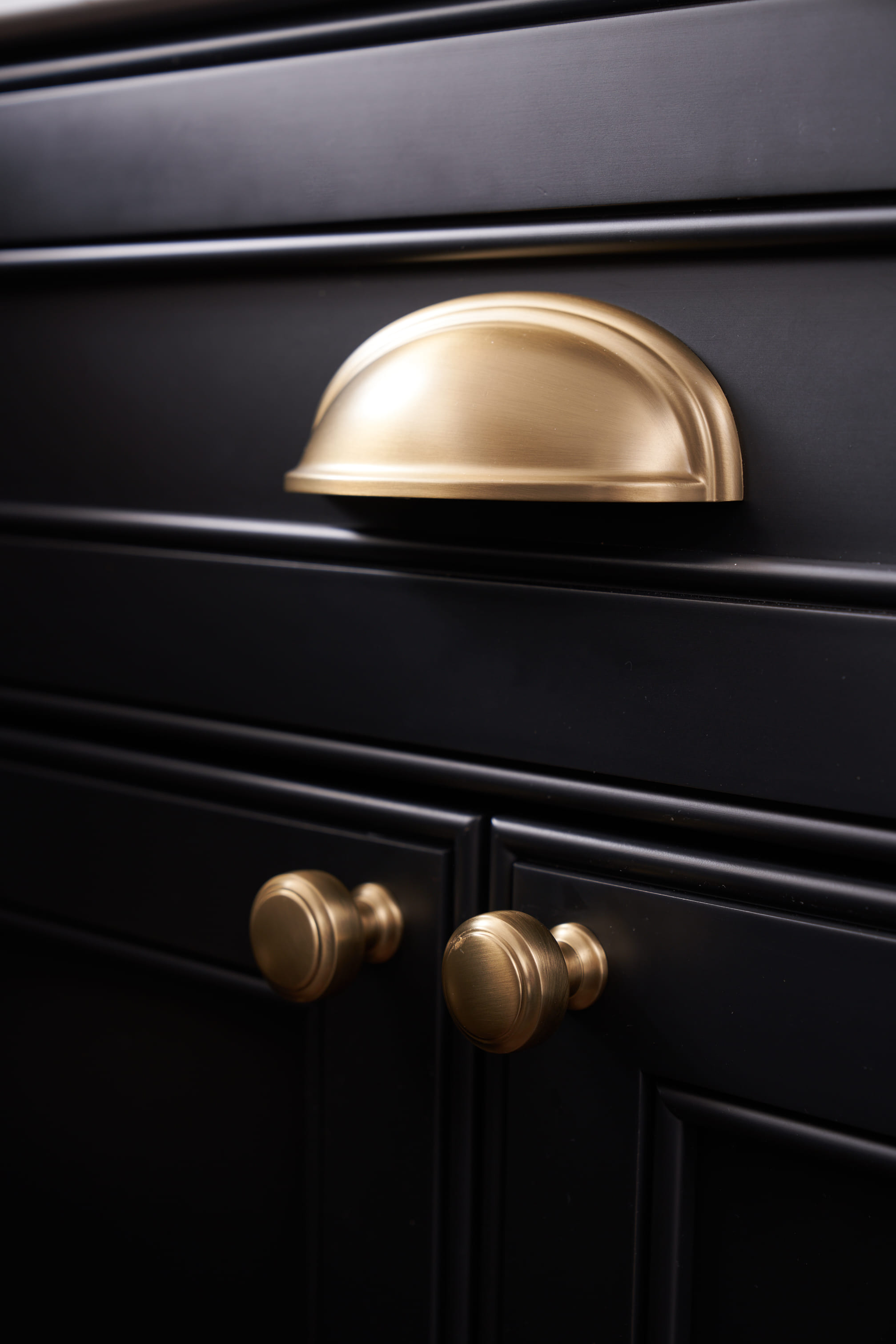 gold hardware on black cabinet in renovation