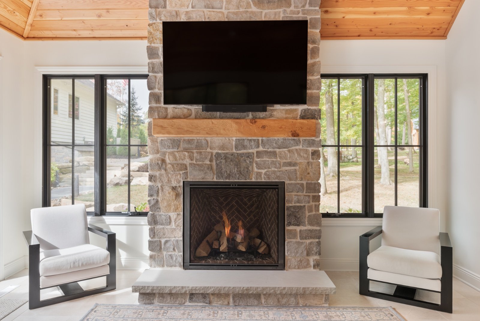 renovated pool house living room with stone fireplace