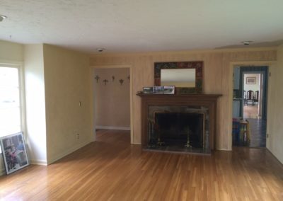 dated wallpapered living room with dark brown fireplace