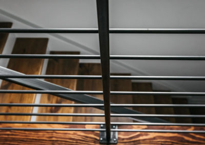 black railing overlooking wood stairs