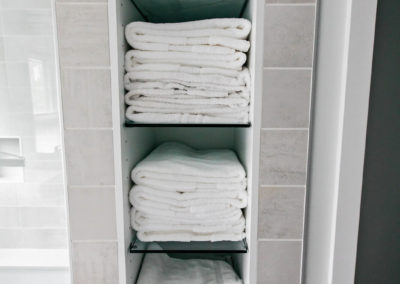 built in linen shelving stacked with white towels