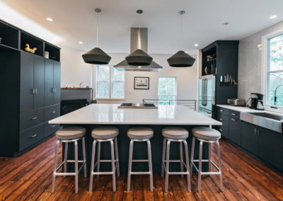 modern kitchen with black cabinets and pendant lighting