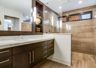 master bathroom with wall mounted vanity and tile shower