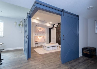 sliding blue barn doors to basement bunk room