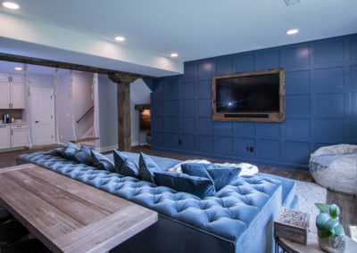 basement entertainment area with blue sofa and wall