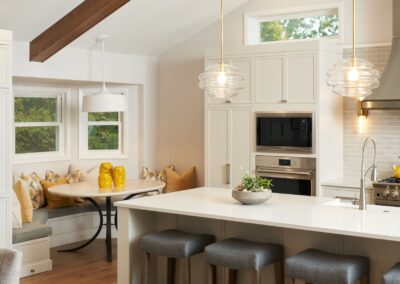 Glass Pendant Lights Over White Island with Stools