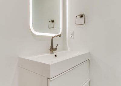 white bathroom vanity with lighted mirror