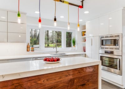 white modern kitchen with multi colored pendant cord light fixture