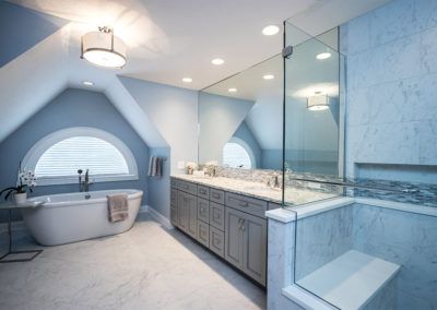 light blue master bathroom with freestanding tub, double vanity and tile shower