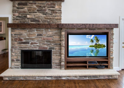 stone fireplace next to built in TV console
