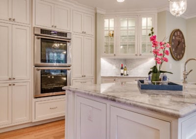 white kitchen with double stainless steel ovens
