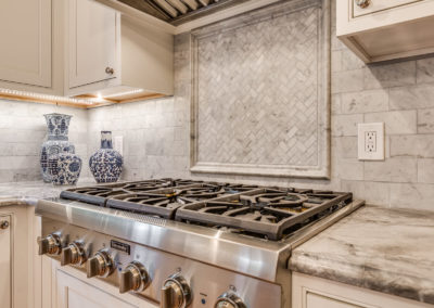 marble tile backsplash behind gas cooking range