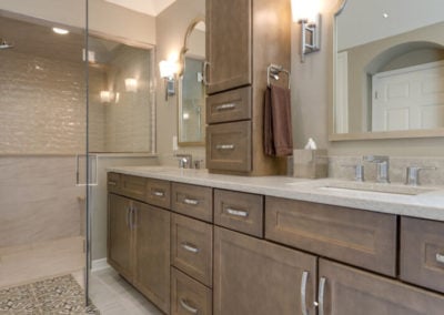 wood vanity with double sinks and center storage tower