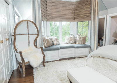 bedroom with window seat and wingback arm chair