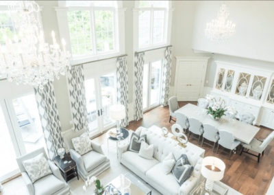 two story dining and living room with crystal chandeliers