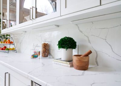 Glass Front White Cabinets Marble Look Countertop and Backsplash