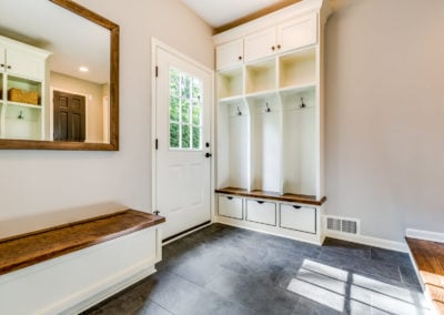 mudroom remodel with built in bench storage and slate tile