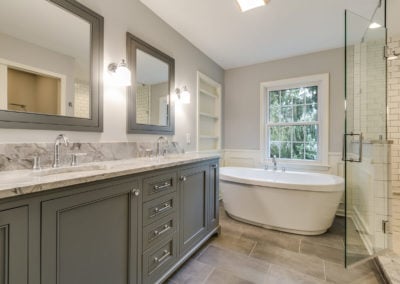 gray bathroom with freestanding tub and glass door shower