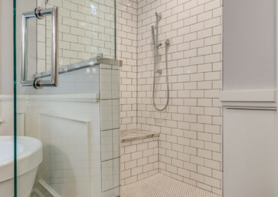 walk in white subway tile shower with bench