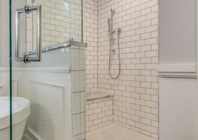 walk in white subway tile shower with bench