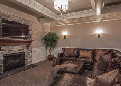 living room with stone fireplace and leather sectional