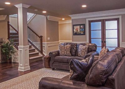 finished basement living area with leather furniture and wood floors