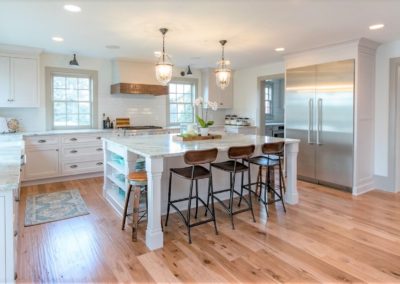 farmhouse kitchen with hickory hardwood floor and white cabinetry
