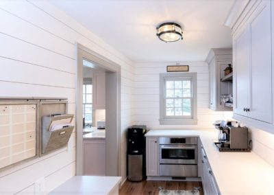 farmhouse pantry with shiplap walls and gray cupboards